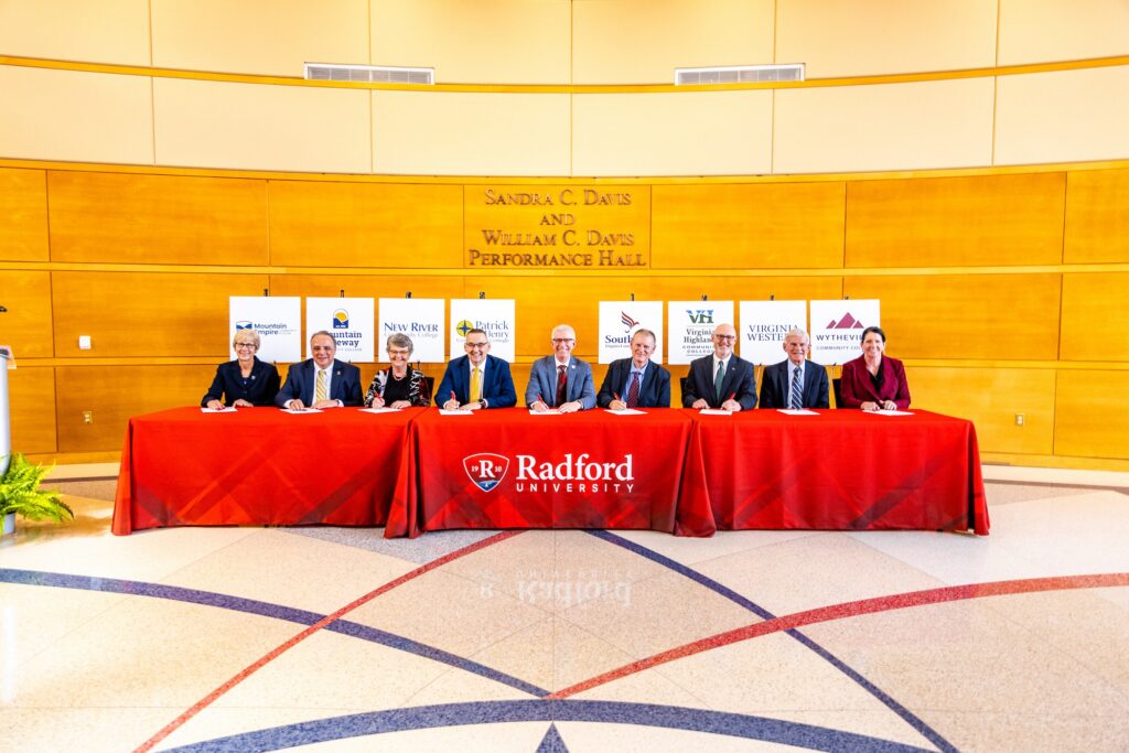 Dr. Robert Sandel (second from right), president of Virginia Western, joins presidents from seven other community colleges and Radford University President Bret Danilowicz (center) in signing documents to launch the Tartan Transfer Program on Nov. 6.