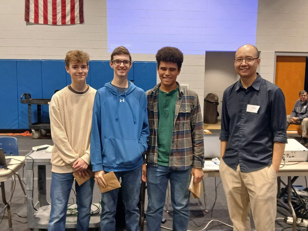 Eli Evans, Ben Escalera and Dominic Thomas, here with Dr. Arnold Yim, were the winning high school team, the Steel Peel Bananas.