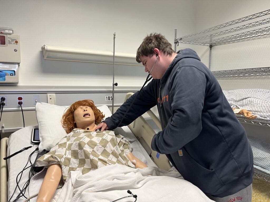 Samuel Smith, a senior at William Fleming High School, works with a simulated patient.